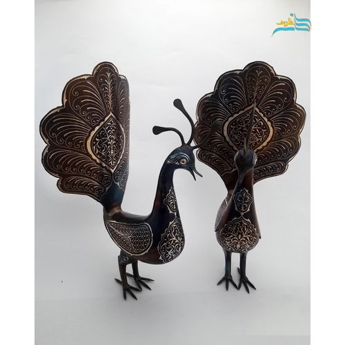 نمای نزدیک از نقره‌کوبی یکدست و با کیفیت عالی روی بدنه فولادی طاووس آنتیک.