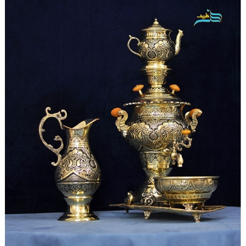 نمای نزدیک سماور برنجی قلم‌زنی اعلاء با جزئیات ظریف سیاه‌قلم و روکش کوره‌ای.