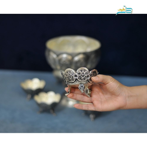 نمای نزدیک آجیل‌خوری کوچک برنجی با سیاه‌قلم و جزئیات ظریف قلم‌زنی.
