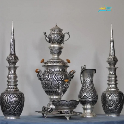 نمای کامل از سرویس شامل سماور و تنگ شاخدار با قلمزنی اسلیمی و روکش نقره، نمایش هماهنگی و زیبایی کلی.
